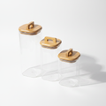 Set of 3 glass storage jars with bamboo lids on white background
